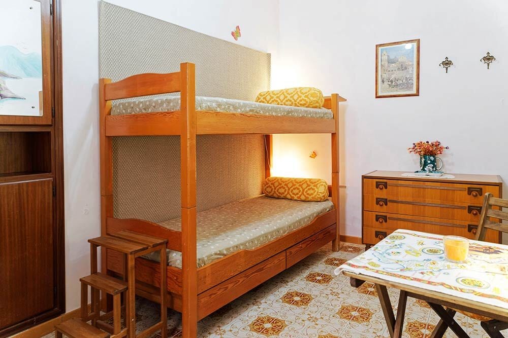 Небольшая уютная комната с двухъярусной кроватью в таунхауе в центре Атрани